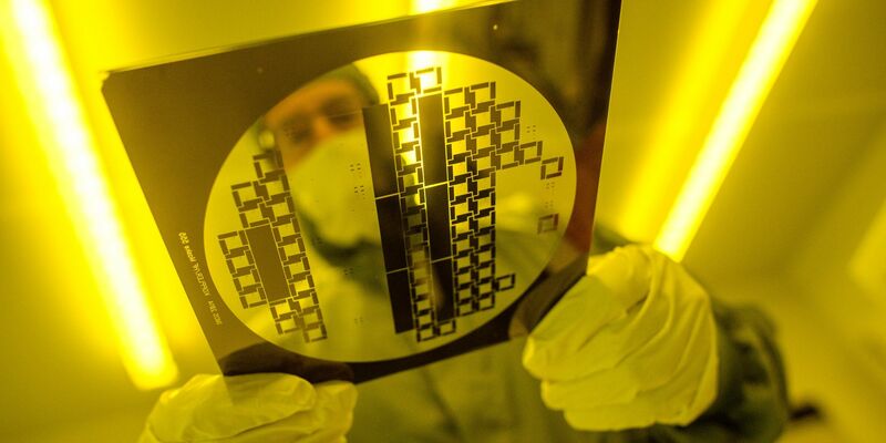 Ein Mann trägt in einem Reinraum eine sogenannte «Maske» zur Herstellung von Halbleiterstrukturen durch den Reinraum. Deutschland hat laut Deloitte gute Voraussetzungen für den Aufbau einer eigenen Chip-Produktion. - Foto: Klaus-Dietmar Gabbert/dpa