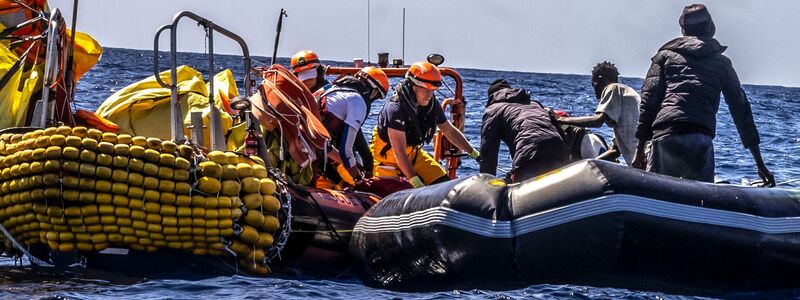Das Rettungspersonal von SOS Mediteranee hilft Migranten bei der Evakuierung eines Schlauchbootes. Überlebende berichteten, dass etwa 50 Menschen während der Fahrt ums Leben gekommen waren. - Foto: Johanna de Tessieres/SOS Mediteranee/AP/dpa