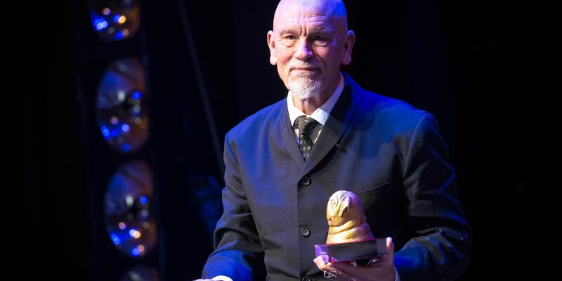 John Malkovich freut sich in Bremen über den «Goldenen Mops». - Foto: Sina Schuldt/dpa