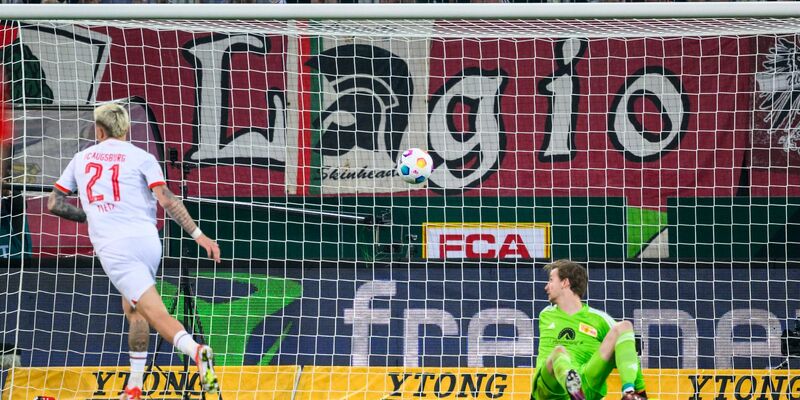 Phillip Tietz (l) brachte Augsburg nach einem verunglückten Rückpass von Unions Diogo Leite in Führung. - Foto: Tom Weller/dpa