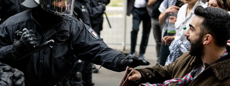 Ein Polizist und ein Demonstrant stoßen bei der Demonstration in Berlin-Mitte aufeinander. Die Polizei war mit rund 900 Kräften in der Stadt im Einsatz. - Foto: Fabian Sommer/dpa