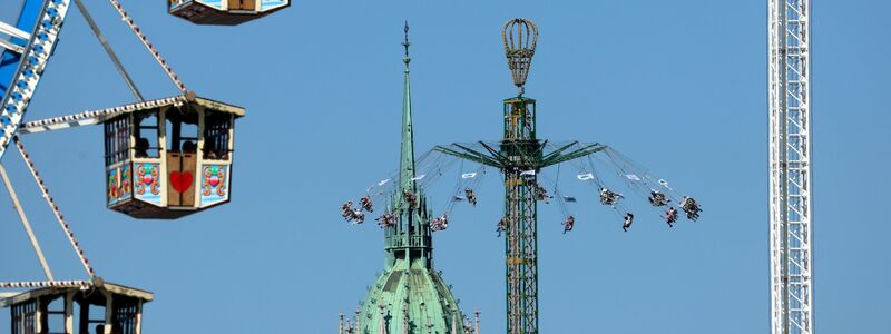 Blasmusiker gehen vor dem Riesenrad über den Festplatz. (Archivbild) - Foto: Karl-Josef Hildenbrand/dpa