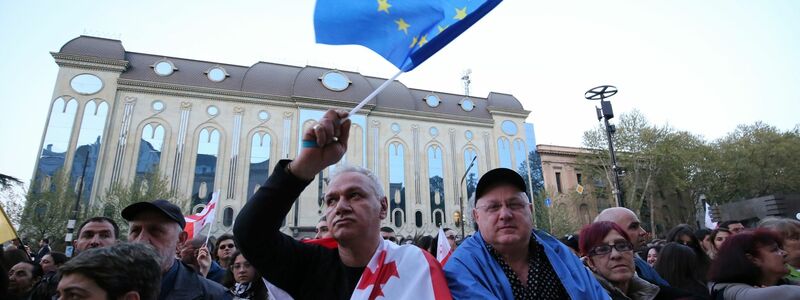 Mit EU- und Georgien-Flagge: Menschen protestieren in Tiflis gegen das umstrittene Gesetz. - Foto: Zurab Tsertsvadze/AP/dpa