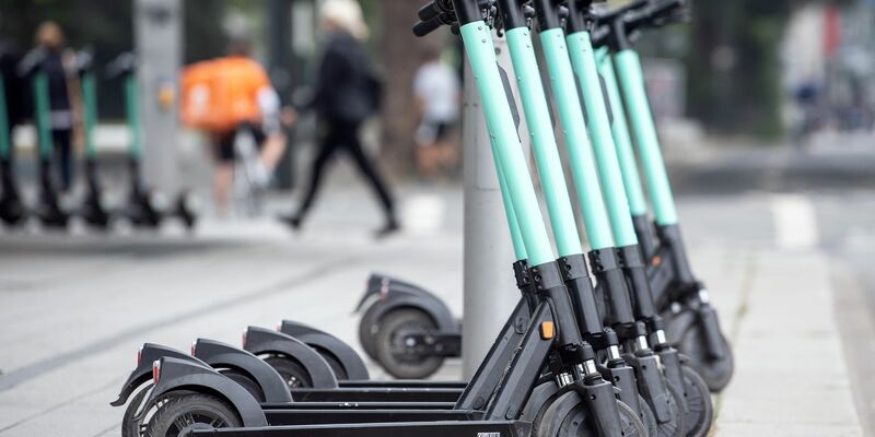 E-Tretroller stehen am Straßenrand. - Foto: Federico Gambarini/dpa