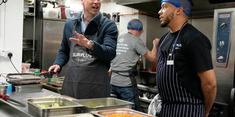 Prinz William (l) hilft dem Chefkoch Mario Confait bei der Herstellung von Bolognese-Sauce. - Foto: Alastair Grant/AP Pool/AP/dpa