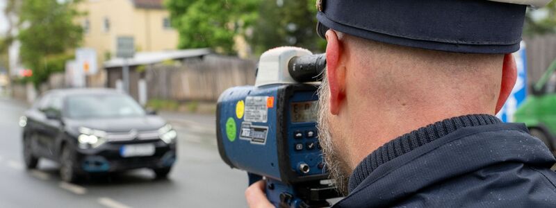Ein Polizeibeamter nimmt in Nürnberg einen Verkehrsteilnehmer mit einem Messgerät ins Visier. - Foto: Pia Bayer/dpa