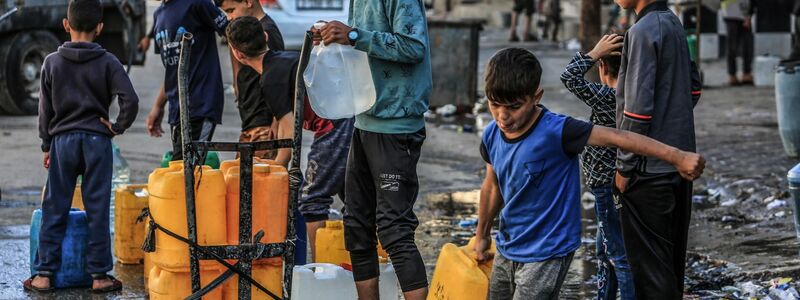 Kinder stehen in Rafah mit Kanistern Schlange, um sie mit Trinkwasser zu füllen. - Foto: Abed Rahim Khatib/dpa