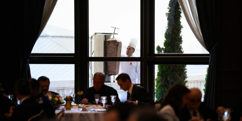 Ein Koch bereitet auf einer Terrasse des Präsidialpalasts Dönerfleisch vom Spieß zu. - Foto: Bernd von Jutrczenka/dpa