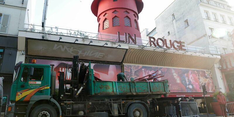 Arbeiter sichern den Bereich vor dem Kabarett, nachdem die Flügel des Windrads des «Moulin Rouge» in der Nacht abgestürzt sind. - Foto: Geoffroy Van Der Hasselt/AFP/dpa