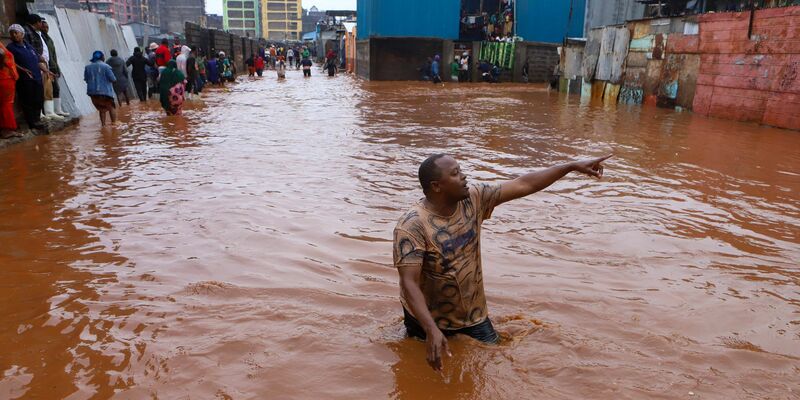 Ein Mann watet in Nairobi durch das Hochwasser. - Foto: Joy Nabukewa/XinHua/dpa