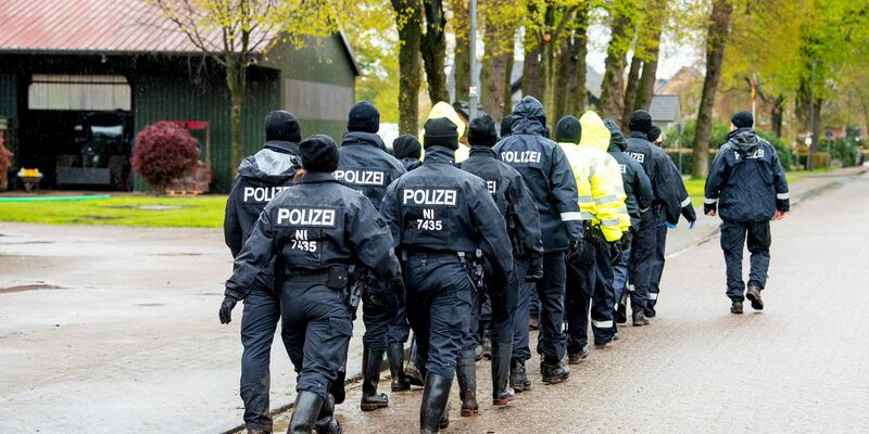 Polizisten gehen auf der Suche nach einem vermissten Jungen durch eine Ortschaft in Niedersachsen. - Foto: Daniel Bockwoldt/dpa