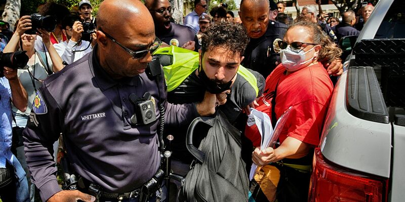 Ein Demonstrant der University of Southern California wird während einer pro-palästinensischen Besetzung des Alumni-Parks in Los Angeles von Beamten des USC Department of Public Safety festgehalten. - Foto: Richard Vogel/AP/dpa