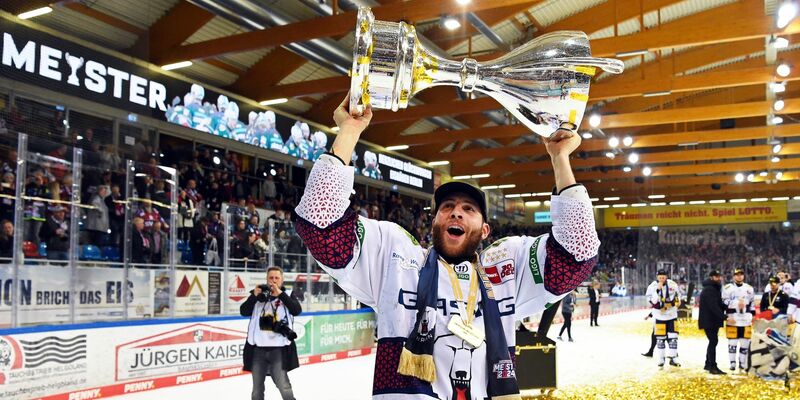 Berlins Yannick Veilleux jubelt nach dem Gewinn der deutschen Eishockey-Meisterschaft mit dem Pokal. - Foto: Carmen Jaspersen/dpa