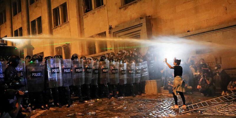 Eine Demonstrantin steht in Tiflis Bereitschaftspolizisten gegenüber. - Foto: Zurab Tsertsvadze/AP/dpa