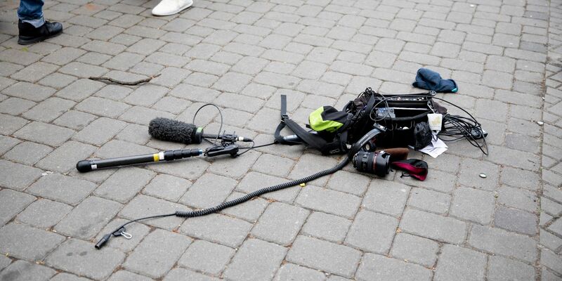 Die Ausrüstung eines Kamerateams liegt nach einem Übergriff in Berlin auf dem Boden. - Foto: Christoph Soeder/dpa