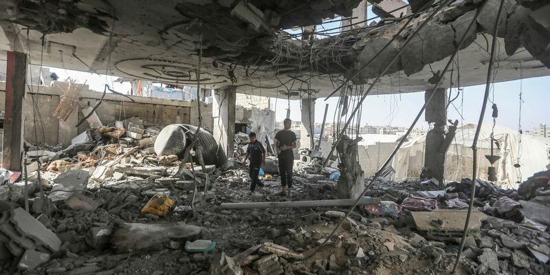 Palästinenser stehen in den Trümmern eines Hauses nach einem israelischen Luftangriff, bei dem mehrere Menschen getötet wurden. - Foto: Ismael Abu Dayyah/AP/dpa