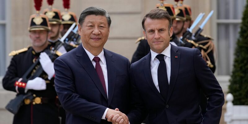 Der französische Präsident Emmanuel Macron (r) begrüßt Chinas Präsident Xi Jinping vor ihrem Treffen im Elysee-Palast. - Foto: Christophe Ena/AP/dpa