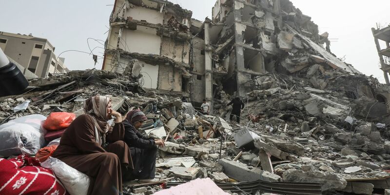 Palästinenserinnen sitzen auf Trümmern im Flüchtlingslager Nuseirat im Gazastreifen nach dem Abzug der israelischen Streitkräfte (IDF). - Foto: Omar Naaman/dpa