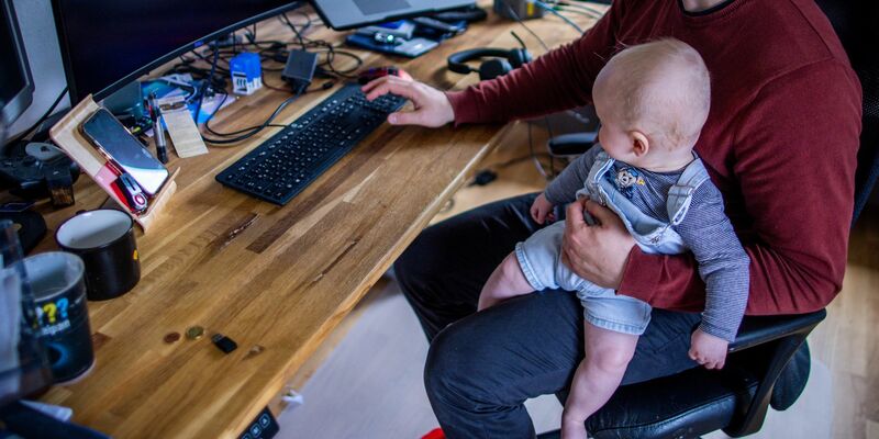 Ein junger Vater im Home-Office mit seinem sechs Monate alten Sohn. - Foto: Jens Büttner/dpa