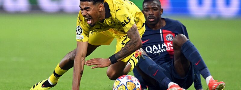 BVB-Verteidiger Ian Maatsen (l) wird von Ousmane Dembelé zu Fall gebracht. - Foto: Robert Michael/dpa