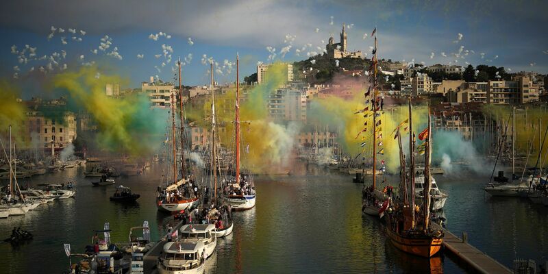 Ein Feuerwerk wurde gezündet, als die olympische Flamme per Schiff in Marseille einlief. - Foto: Daniel Cole/AP/dpa