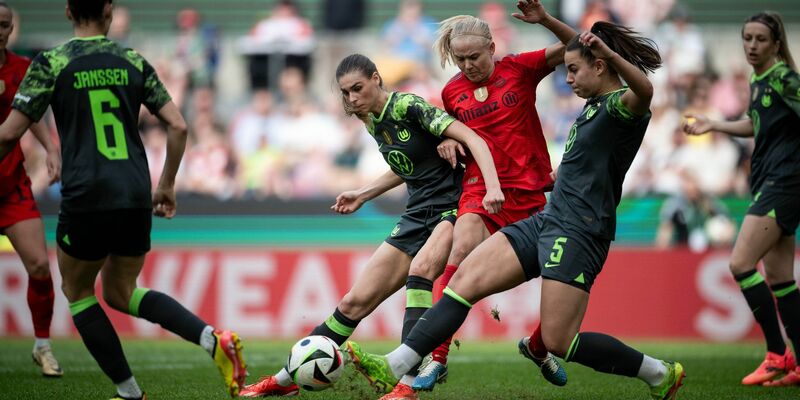 Wolfsburgs Jule Brand (l) und Lena Oberdorf kämpfen mit Bayerns Pernille Harder um den Ball. - Foto: Fabian Strauch/dpa
