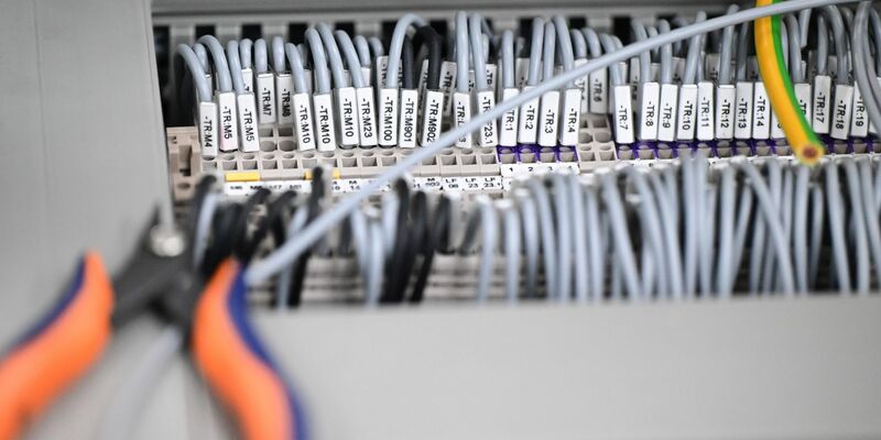 Kabelstränge liegen in einer Produktionshalle: Das Geschäftsklima in der deutschen Elektro- und Digitalindustrie ist zurückgefallen. - Foto: Bernd Weißbrod/dpa