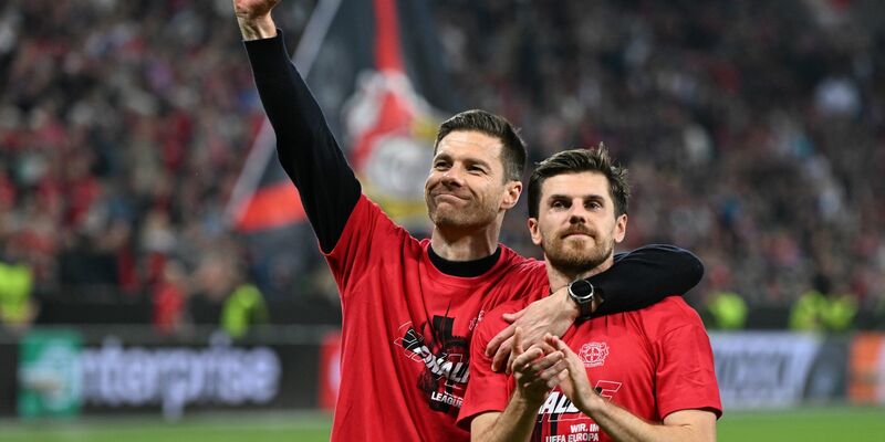 Leverkusens Trainer Xabi Alonso und Jonas Hofmann (r) feiern mit den Fans nach dem Spiel gegen Rom. - Foto: Federico Gambarini/dpa