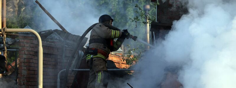 Nach einem russischen Angriff bei Charkiw versuchen ukrainische Rettungskräfte ein Feuer zu löschen. - Foto: Not credited/https://photonew.ukrinform.com/ Ukrinform/dpa