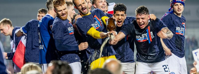 Die Spieler von Kiel feiern mit den Fans gemeinsam den Aufstieg. - Foto: Axel Heimken/dpa