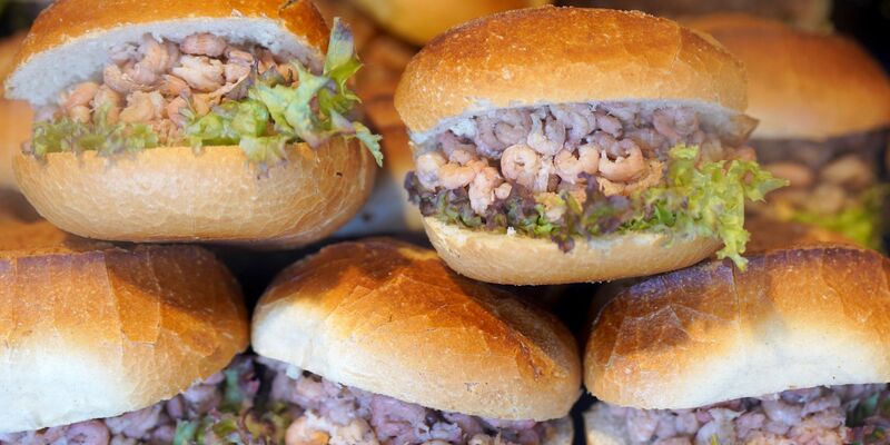 Brötchen mit Nordseekrabben in der Auslage eines Fischbrötchen-Imbisses an den Hamburger Landungsbrücken. - Foto: Marcus Brandt/dpa