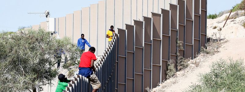 Migranten klettern über einen Zaun auf der italienischen Insel Lampedusa. - Foto: Cecilia Fabiano/LaPresse via ZUMA Press/dpa