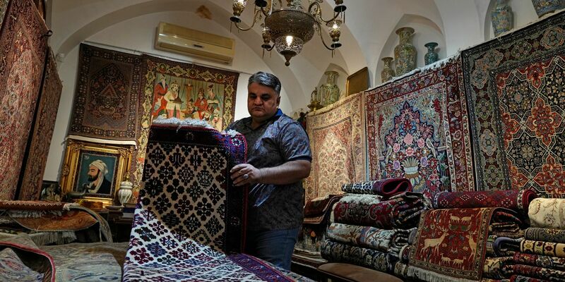 Ein iranischer Teppichhändler arbeitet in seinem Geschäft auf dem traditionellen Basar der Stadt Kashan. - Foto: Vahid Salemi/AP/dpa