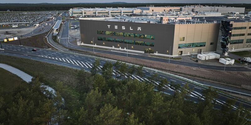 Blick am frühen Morgen auf das Tesla-Werk: Begleitet von Protest stimmt die Gemeinde Grünheide heute über Ausbaupläne des US-Elektroautobauers Tesla ab. - Foto: Joerg Carstensen/dpa