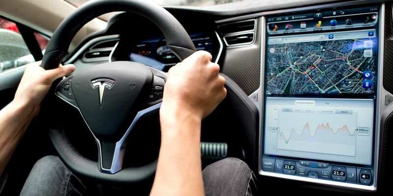 Ein Mann sitzt in einem Tesla Model S am Lenkrad: Elon Musk sagt, er sei mit seinen Versprechen zu selbstfahrenden Autos oft zu optimistisch gewesen. - Foto: Sven Hoppe/dpa