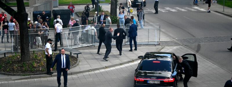 Leibwächter bringen den slowakischen Regierungschef Robert Fico nach dem Attentat in einem Auto in Sicherheit. - Foto: Radovan Stoklasa/TASR/dpa