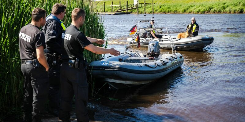 Einsatzkräfte der Polizei fahren bei der Suche nach dem vermissten Arian mit Spürhunden auf Schlauchbooten über die Oste. - Foto: Sina Schuldt/dpa