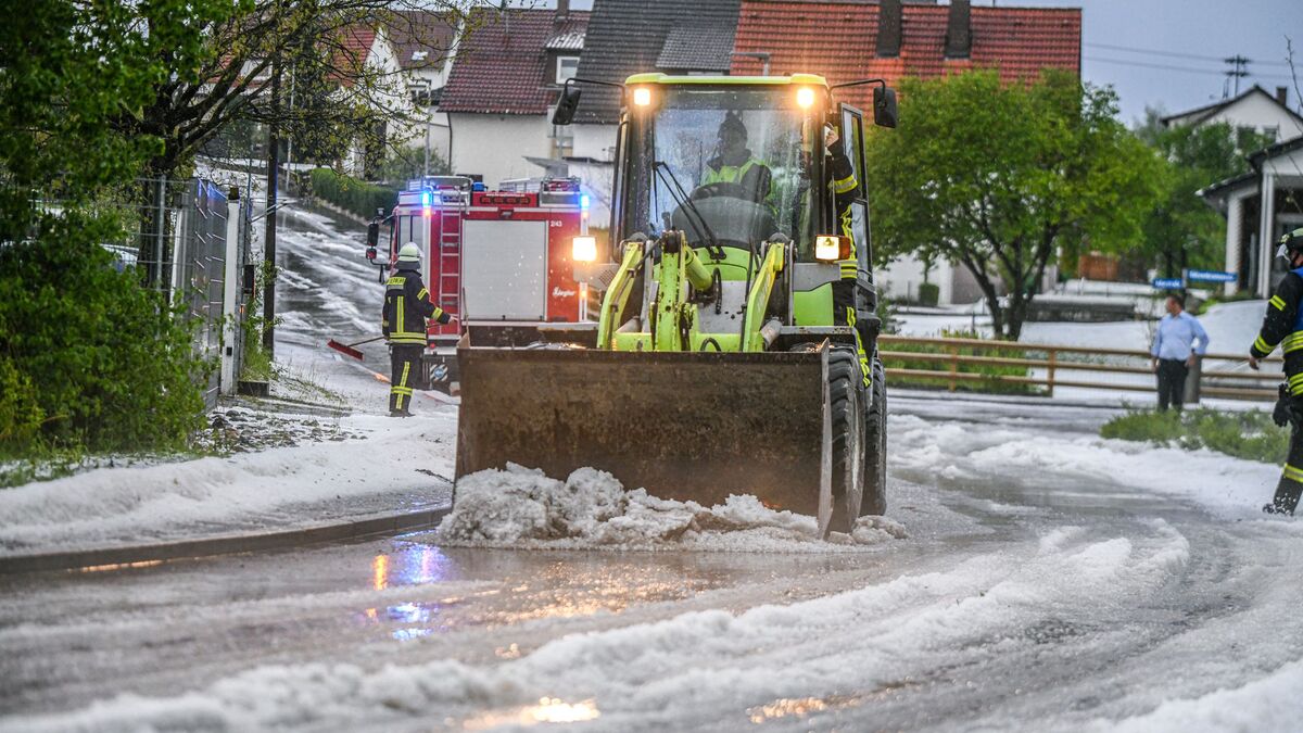 Einsatzkräfte der Feuerwehr räumen nach einem Hagelscheuer eine Straße in Söhnstetten im Landkreis Heidenheim (Baden-Württemberg). - Foto: Jason Tschepljakow/dpa