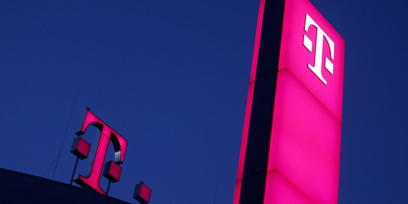 Das Logo der Deutschen Telekom leuchtet auf dem Dach der Unternehmenszentrale. - Foto: Oliver Berg/dpa