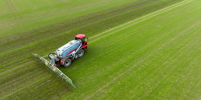 Ein Landwirt bringt mit seinem Gespann Gülle im sogenannten Schleppschuh Verfahren auf einem Feld aus. - Foto: Philipp Schulze/dpa