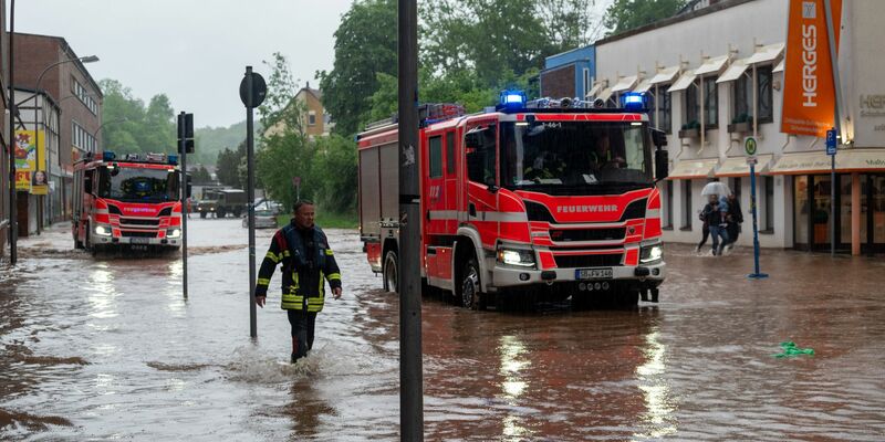Feuerwehrleute bewegen sich durch das Hochwasser in Saarbrücken. - Foto: Harald Tittel/dpa