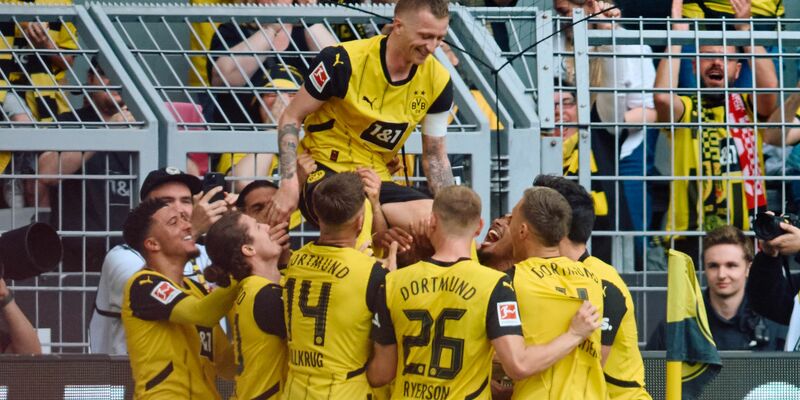 Die Dortmunder Spieler bejubeln mit Marco Reus sein Tor zum 2:0. - Foto: Bernd Thissen/dpa