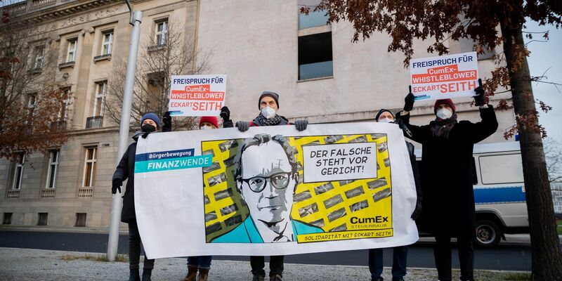 Gerhard Schick (M) nimmt an einer Solidaritätsaktion der Bürgerbewegung Finanzwende für CumEx-Hinweisgeber Eckart Seith teil. - Foto: Christoph Soeder/dpa