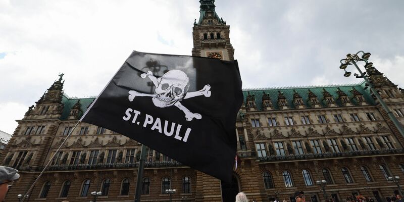 Fans des FC St. Pauli sammeln sich für die Aufstiegsfeier auf dem Rathausmarkt vor dem Rathaus. - Foto: Christian Charisius/dpa
