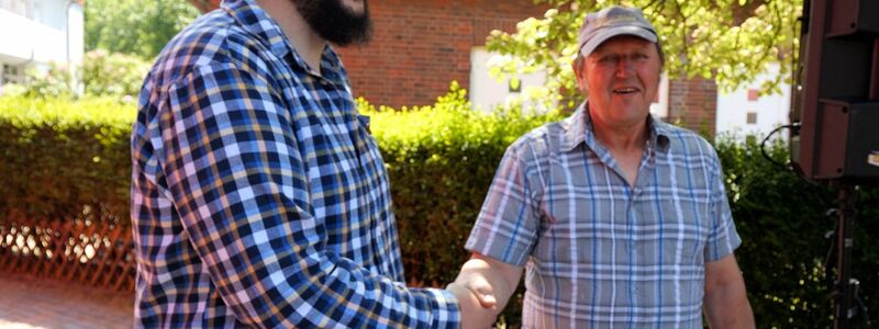 Daniel Jochheim (l), der neue Leuchtturmwärter auf Wangerooge, wird von seinem Vorgänger Jan Gerdes begrüßt. - Foto: Jörn Hüneke/dpa