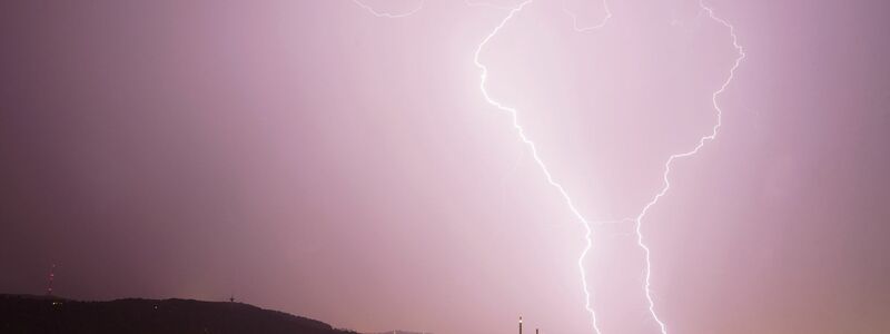 Zwei Blitze entladen sich bei einem  Gewitter über Stuttgart. - Foto: Andreas Rosar/dpa