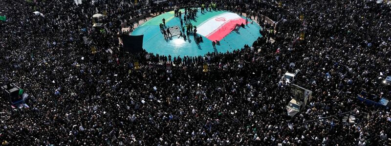 Frauen erinnern mit Plakaten an den verstorbenen Präsidenten. - Foto: Vahid Salemi/AP/dpa