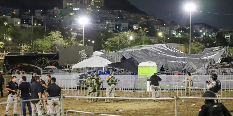 Sicherheitskräfte stehen um die Bühne, die zusammengebrochen ist. - Foto: Alberto Lopez/AP/dpa