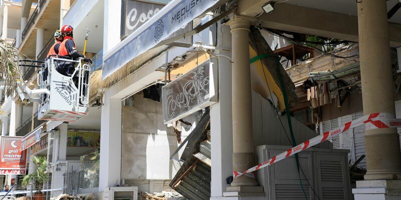 Polizeibeamte vor dem Gebäude des Medusa Beach Club auf Mallorca nach dem Einsturz. - Foto: Clara Margais/dpa