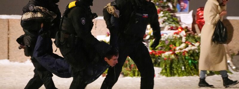 Polizeibeamte halten einen Mann fest, der Blumen zu Ehren von Alexej Nawalny an einem Denkmal für die Opfer der sowjetischen Unterdrückung in St. Petersburg niedergelegt hat. - Foto: Uncredited/AP/dpa